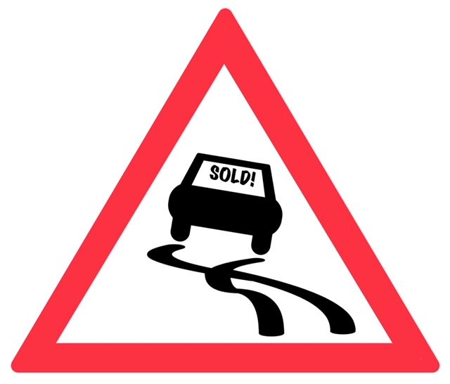 A car with a “sold!” sticker skidding on the road